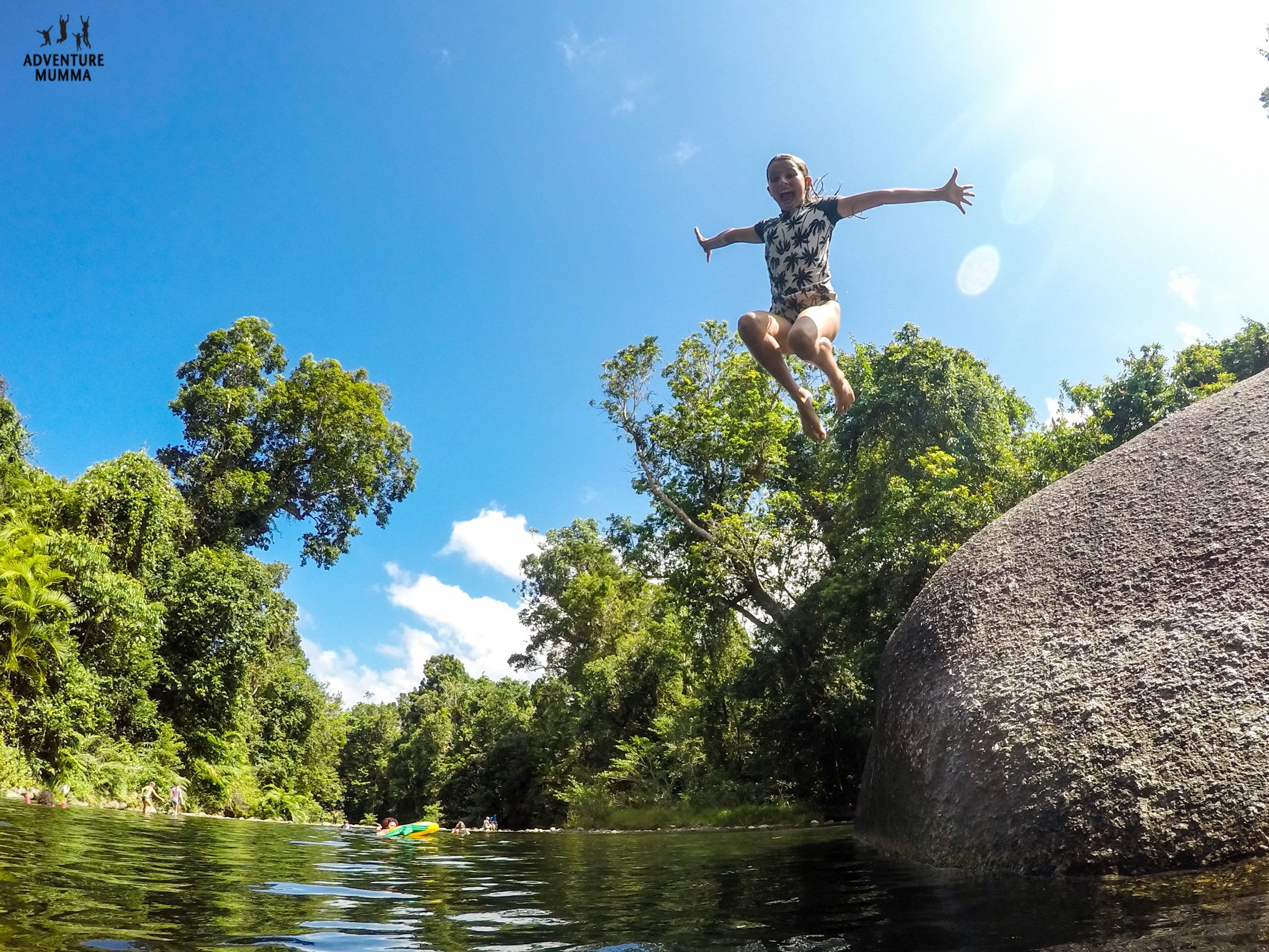 Family splashing in crystal-clear water at a Cairns lagoon. Fun in Far North Queensland!