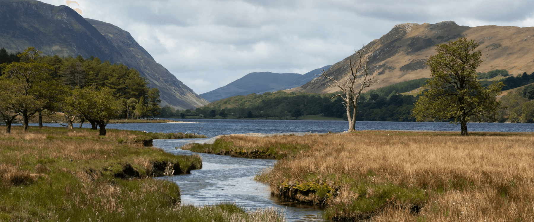 Couple canoeing on a tranquil lake in the Lake District; romantic getaway.
