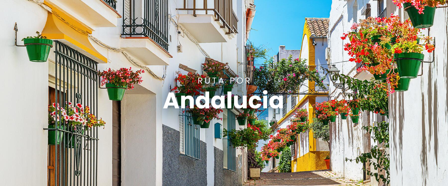 Autocaravana en carretera andaluza con pueblos blancos al fondo, disfrutando de la ruta.