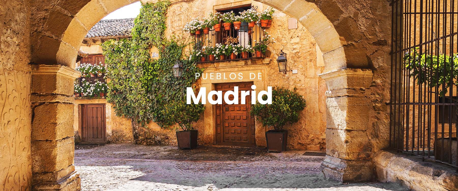 Pueblo medieval con montañas al fondo, cerca de Madrid.