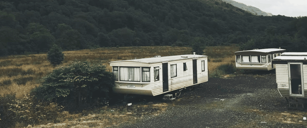 Caravan parked at sunny holiday park, family enjoying a camping trip.