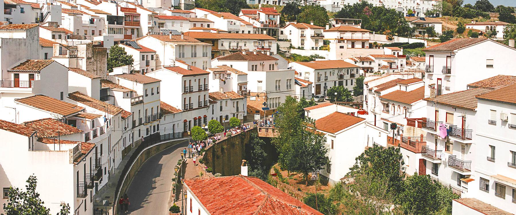 Autocaravana estacionada en pueblo blanco andaluz, con vistas a las montañas.