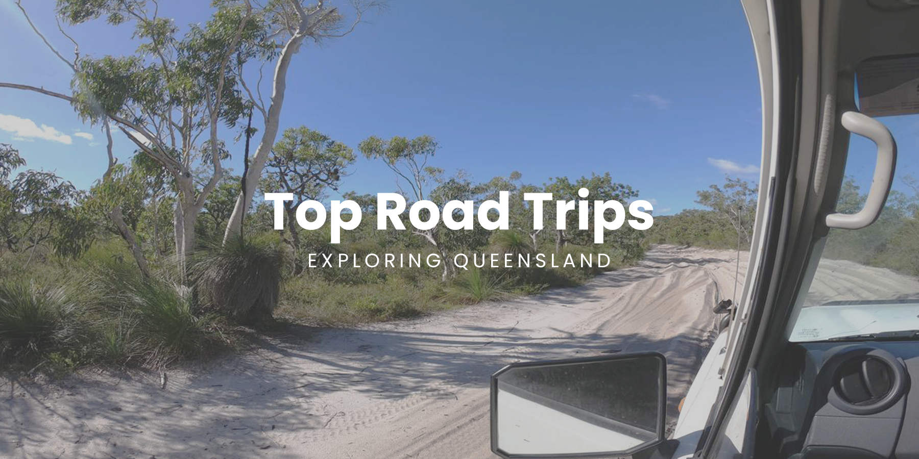 Campervan parked near a lush rainforest, perfect for a Queensland road trip.