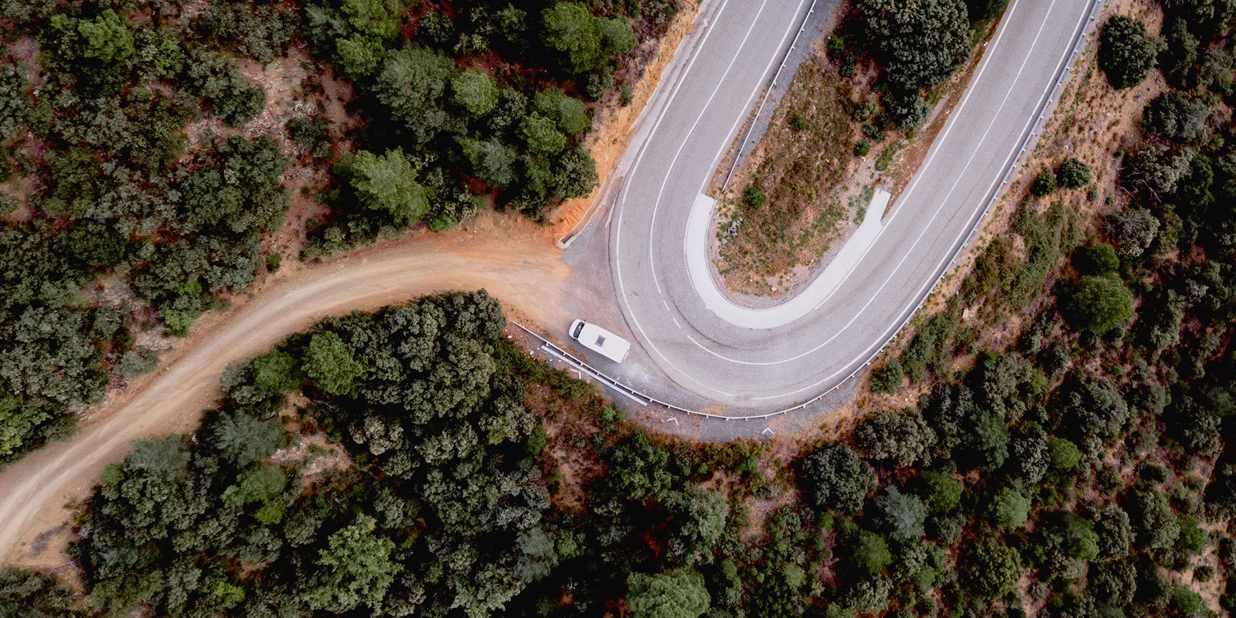 Autocaravana viajando por carretera en paisaje de montaña. Vacaciones y aventura en camper.