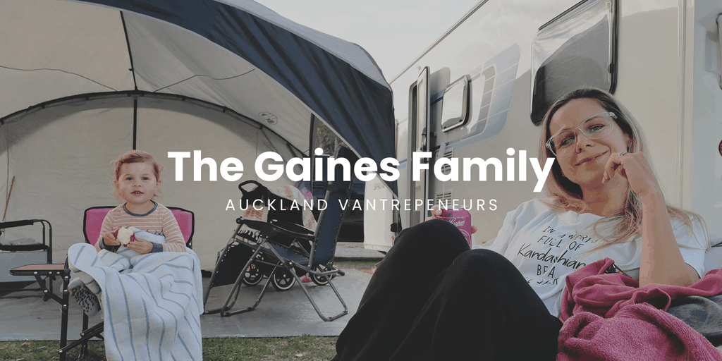 Couple toasting sun setting behind their campervan, Coromandel coast.