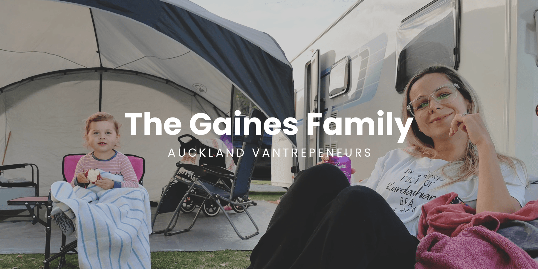 Couple toasting sun setting behind their campervan, Coromandel coast.