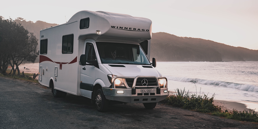 Luxury motorhome parked by a scenic loch, perfect for a glamping holiday in the Scottish Highlands.