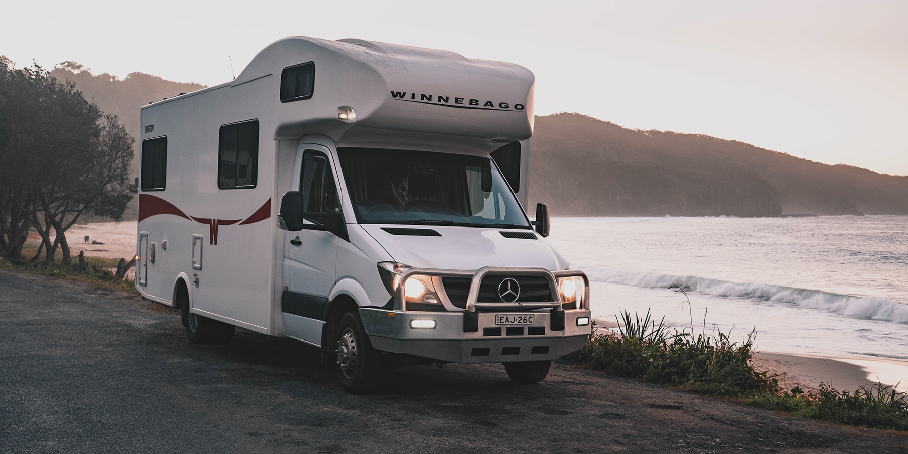 Luxury motorhome parked by a scenic loch, perfect for a glamping holiday in the Scottish Highlands.