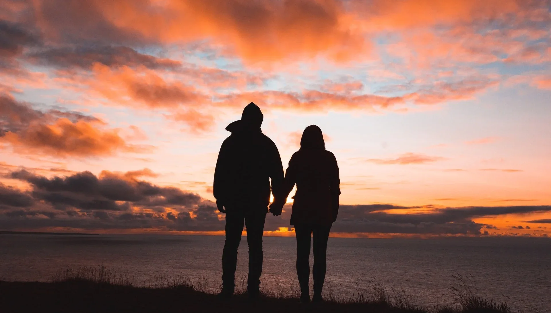 Campervan parked by a scenic lake at sunset, Valentine's decorations visible inside.