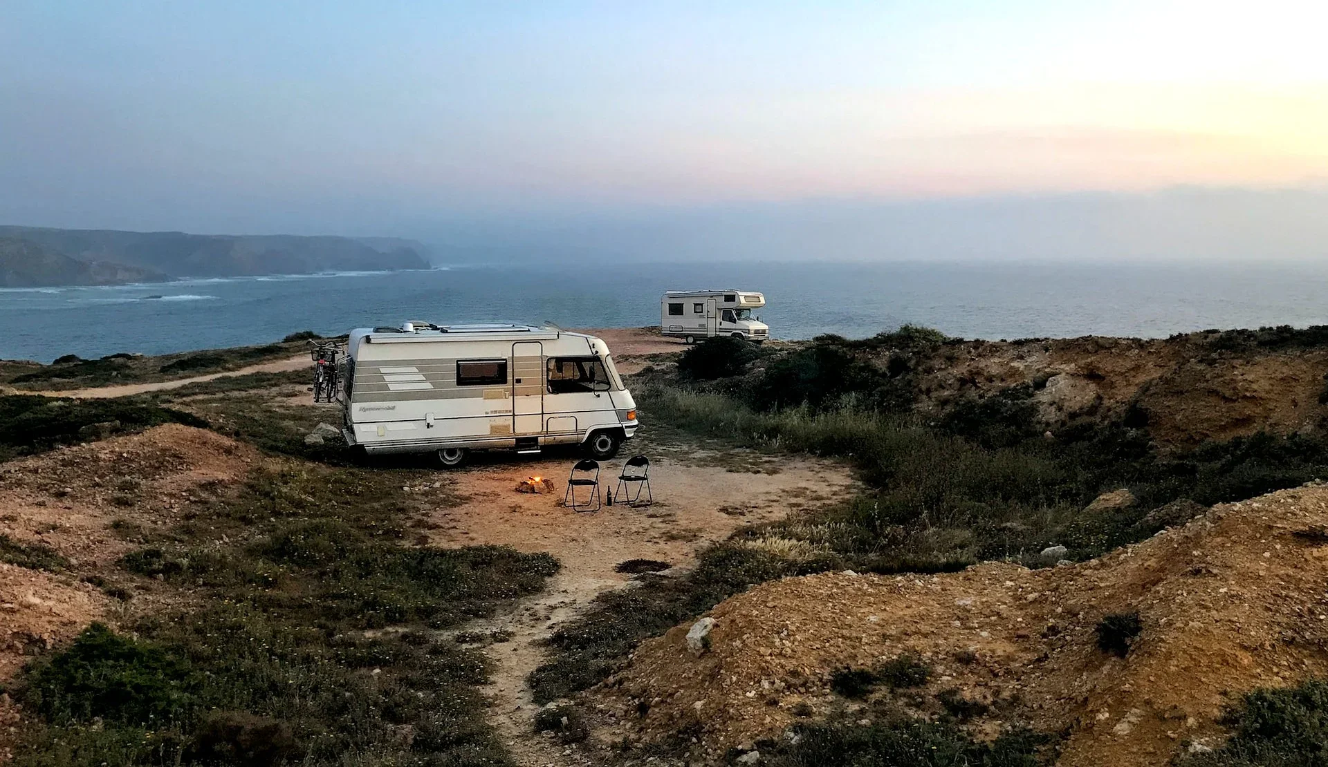 Campervan overlooks Algarve coastline. Winter camping in Portugal.