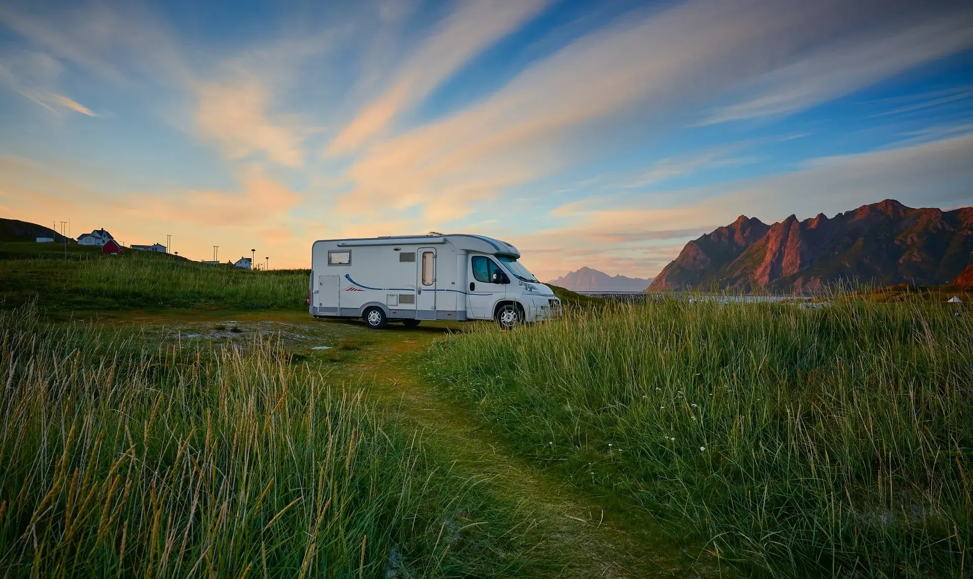 Tent pitched in Peak District valley at dusk, hikers silhouetted against hills.