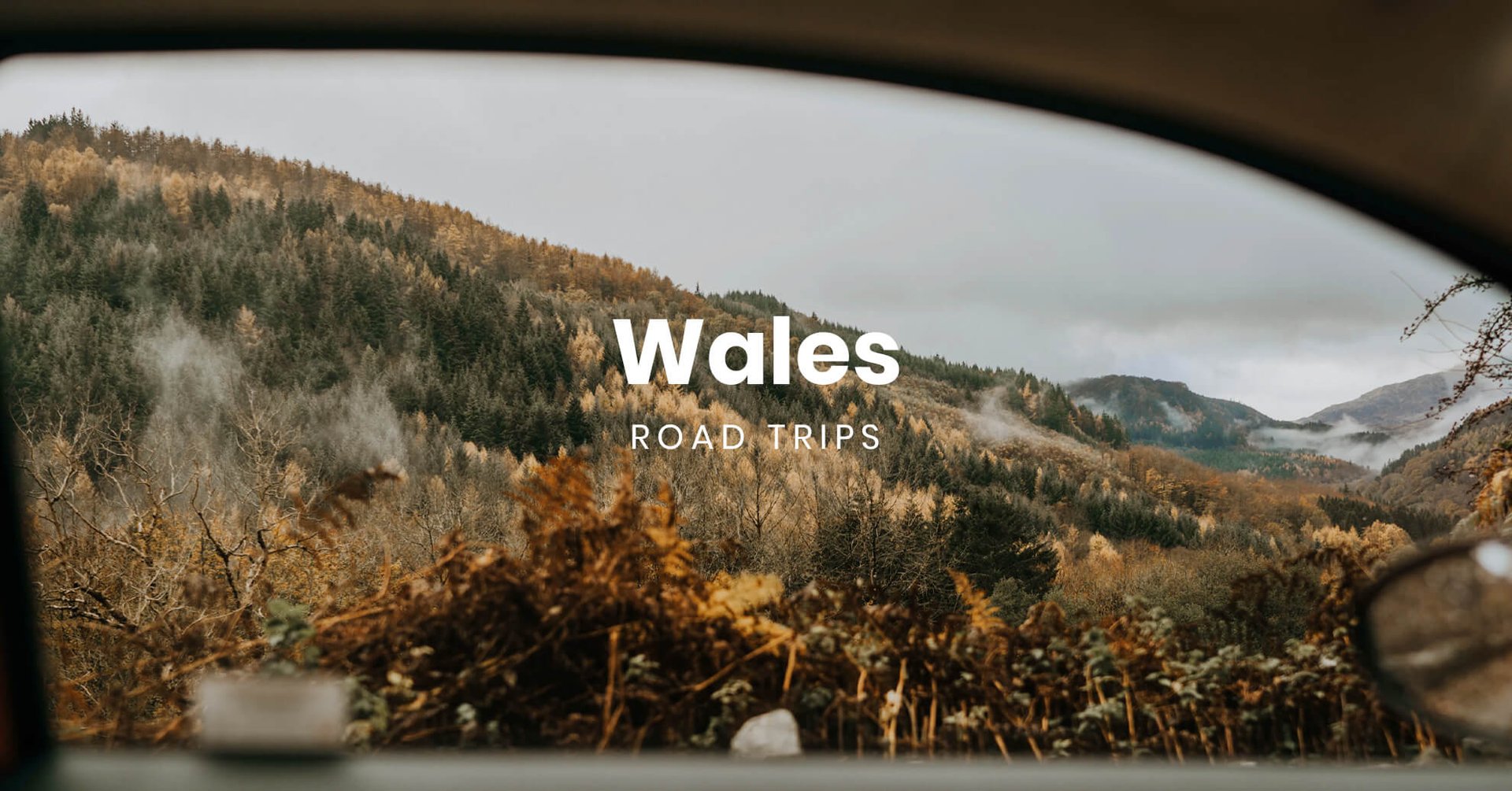 Campervan on scenic Welsh road trip, surrounded by rolling hills and dramatic coastline.