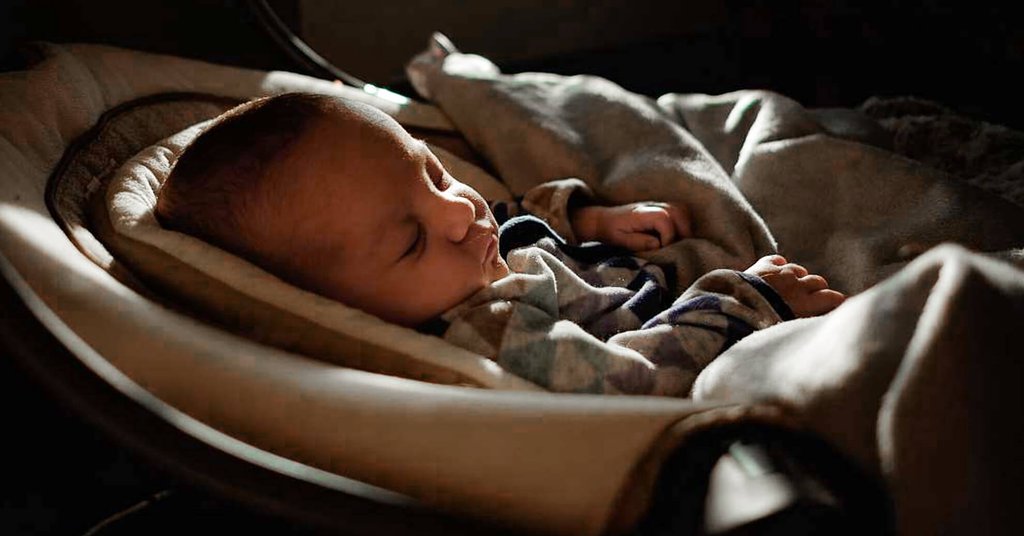 Familia feliz frente a autocaravana en camping soleado. Viajar con bebé.