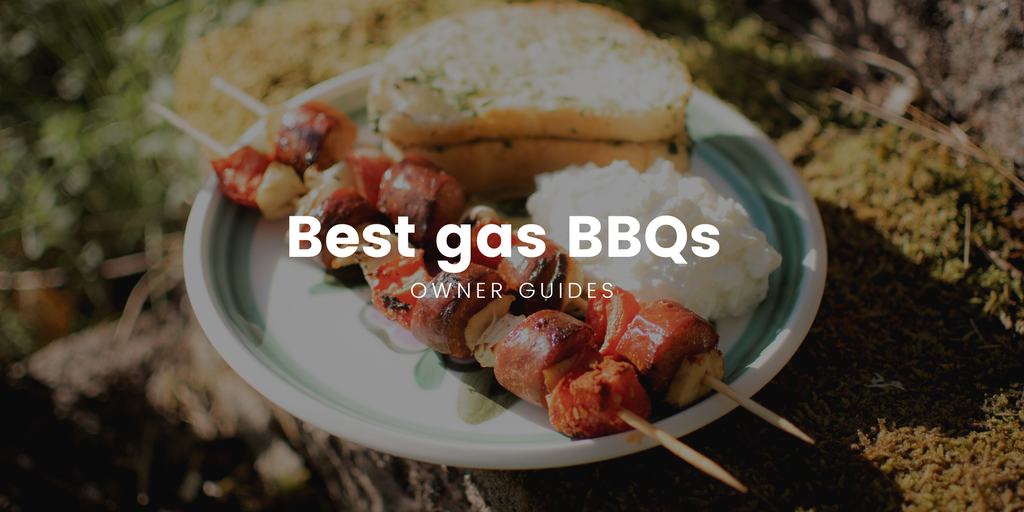 Motorhome parked by a lake, BBQ lit, family enjoying a campsite cookout.