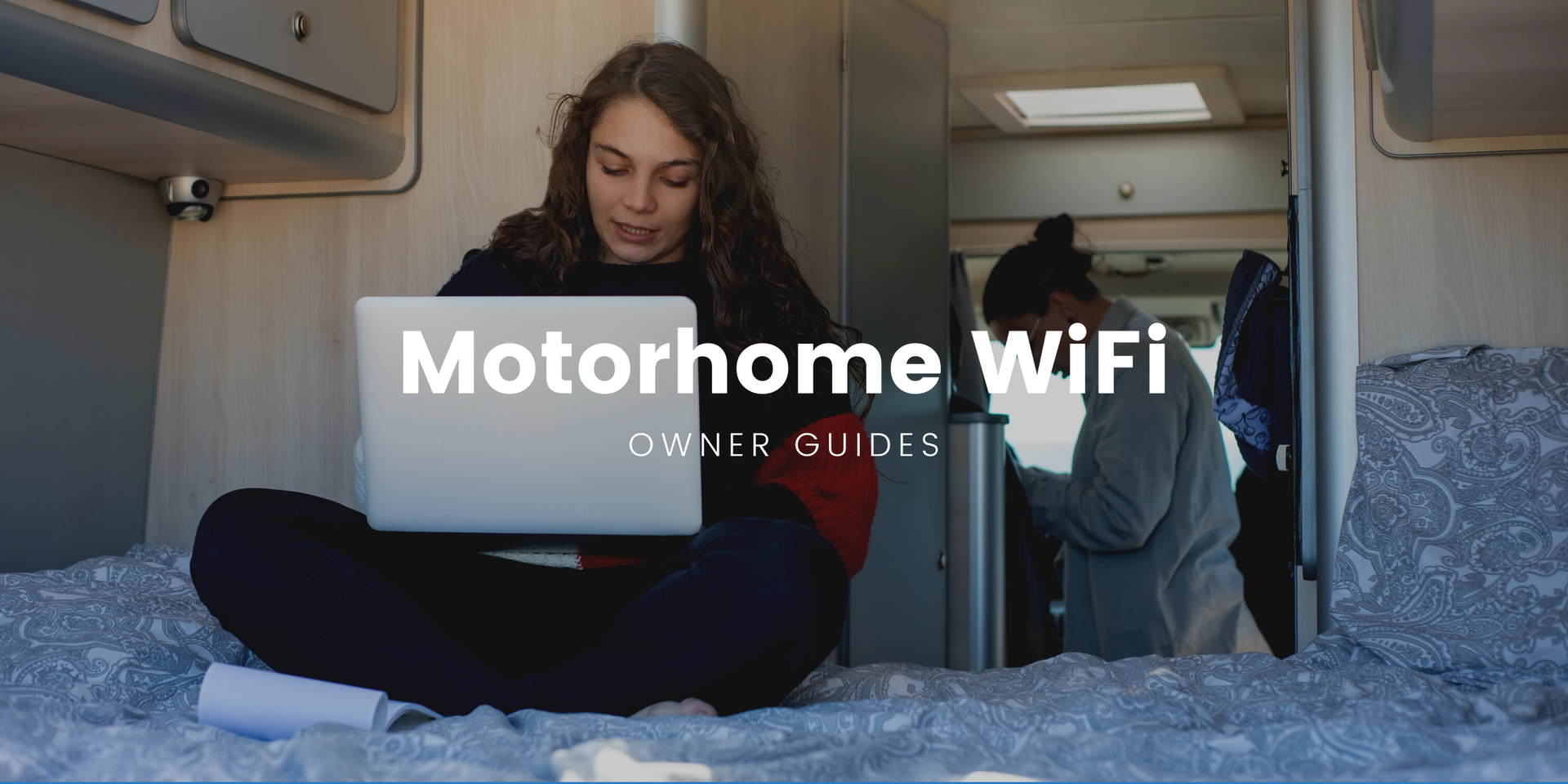 Motorhome parked up in scenic campsite, connected to WiFi, laptops visible inside.