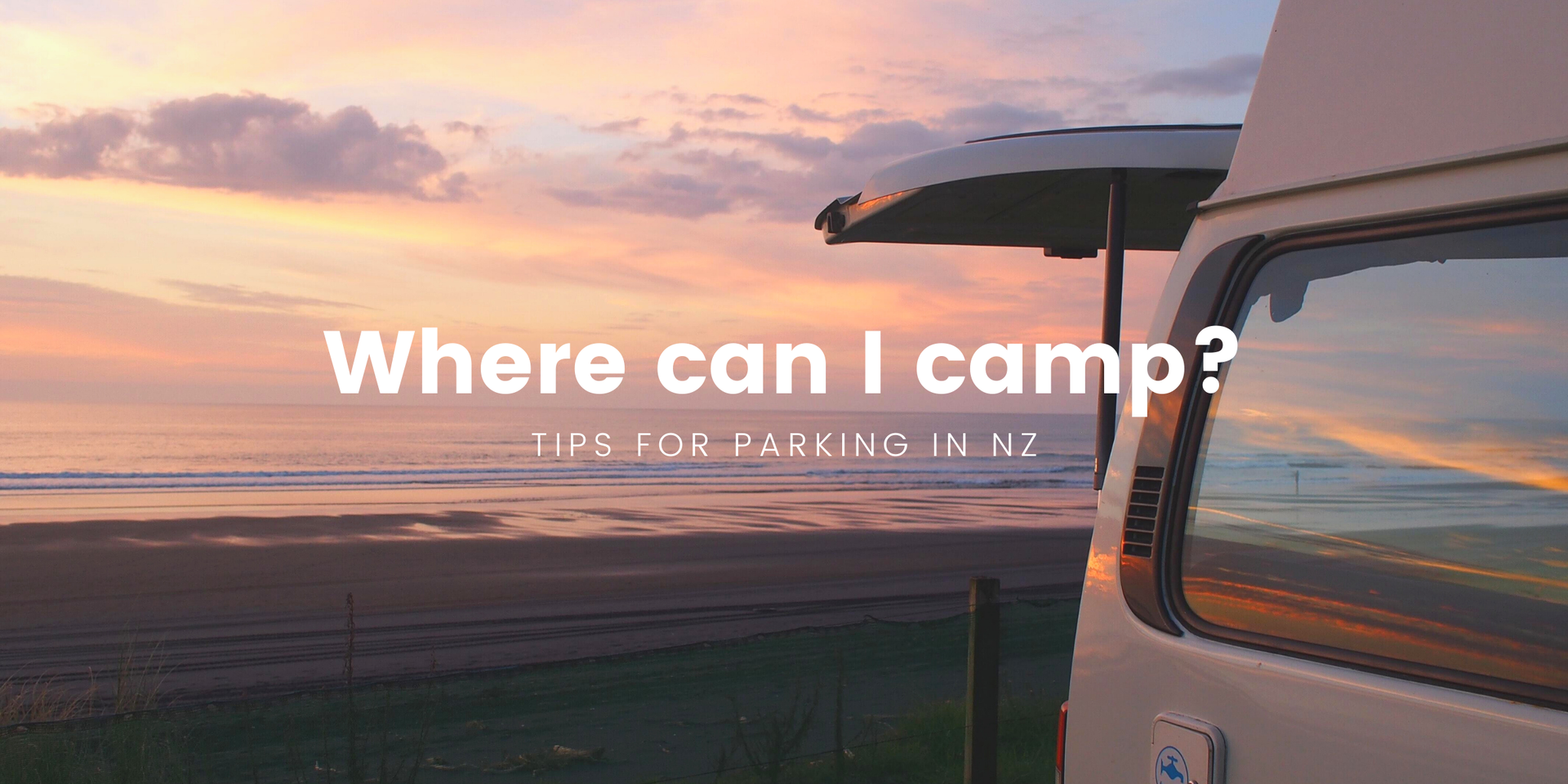 Campervan parked at a scenic campsite in Aotearoa, overlooking mountains and a lake.