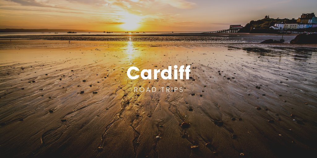 Caravan parked by a scenic Welsh lake with mountains in the distance, perfect for a Cardiff road trip.