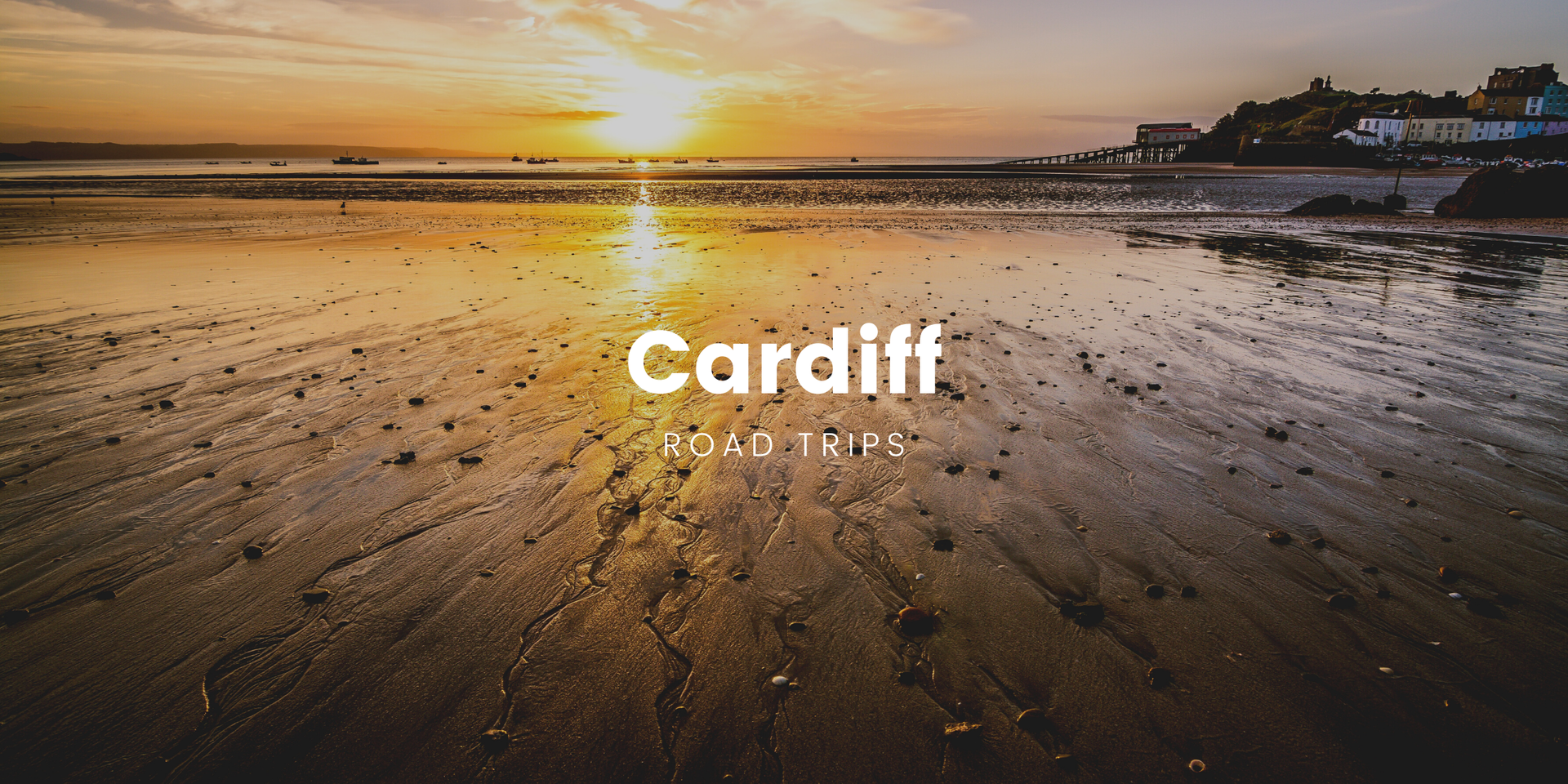 Caravan parked by a scenic Welsh lake with mountains in the distance, perfect for a Cardiff road trip.