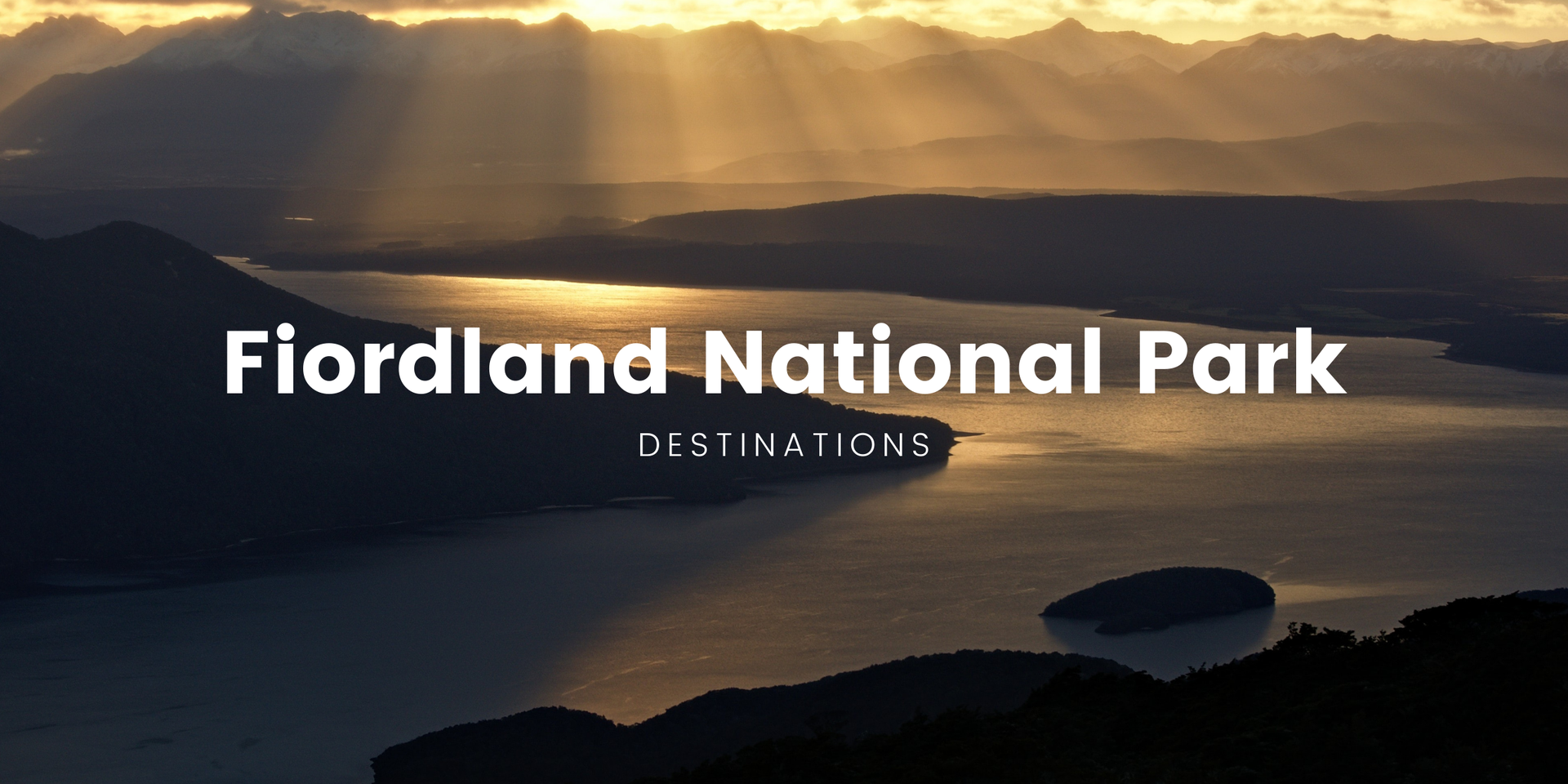 Snow-capped mountains reflected in glassy lake, perfect for a Fiordland camping holiday.