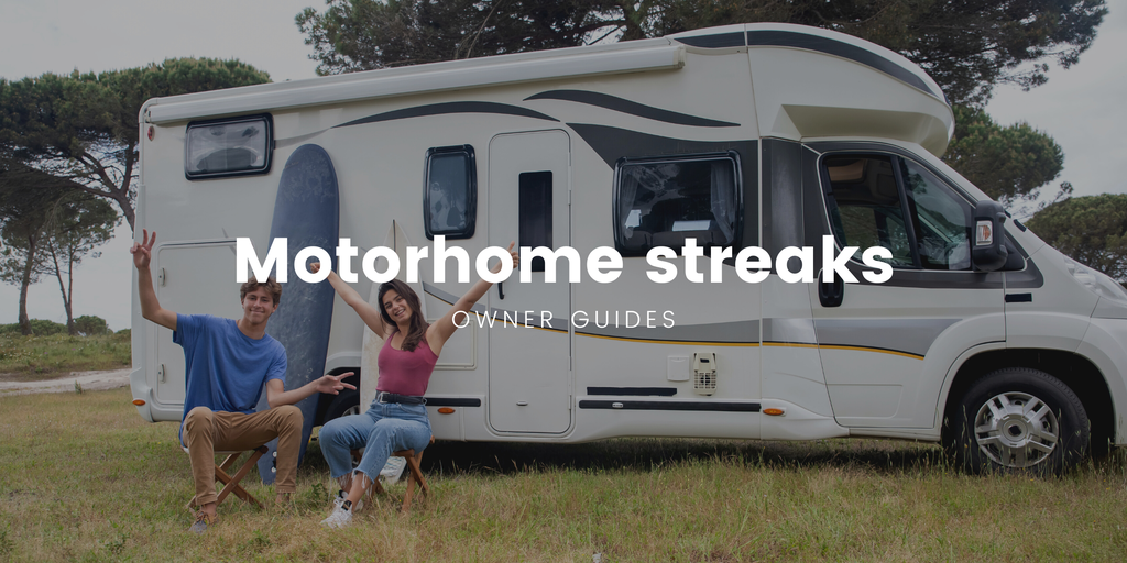 Motorhome sparkling clean after removing black streaks, parked at a sunny campsite.