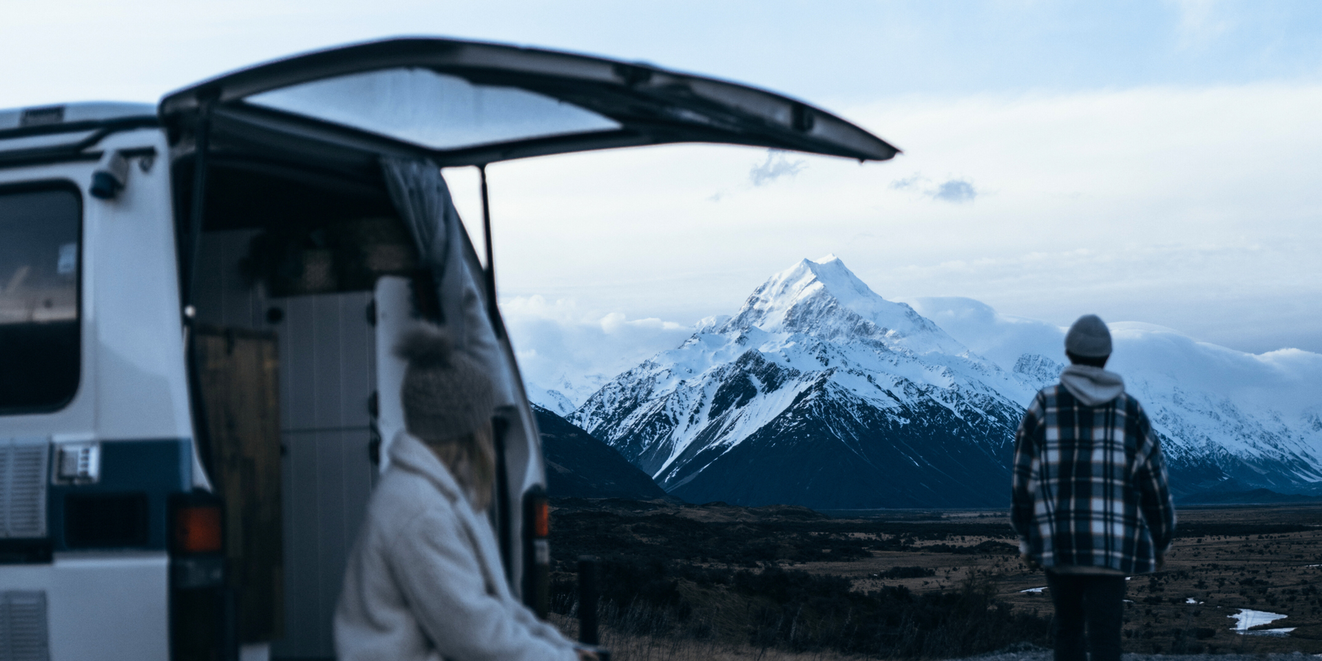 Campervan parked up in snowy mountains, winter camping in the backcountry.