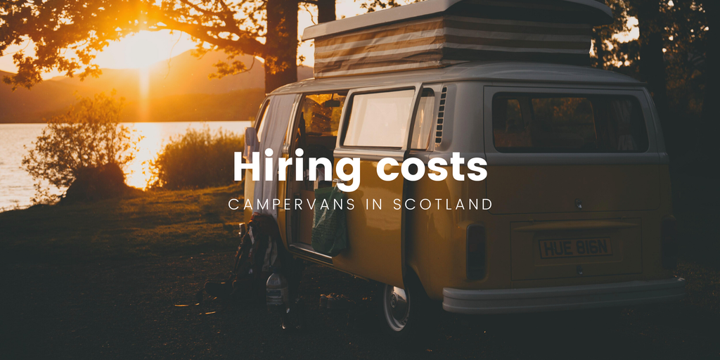 Campervan parked by a Scottish loch with mountains in the background.