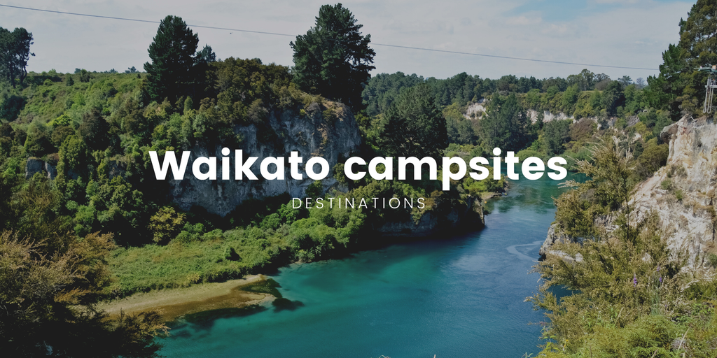 Tents pitched at a scenic Waikato camping ground, surrounded by native bush.