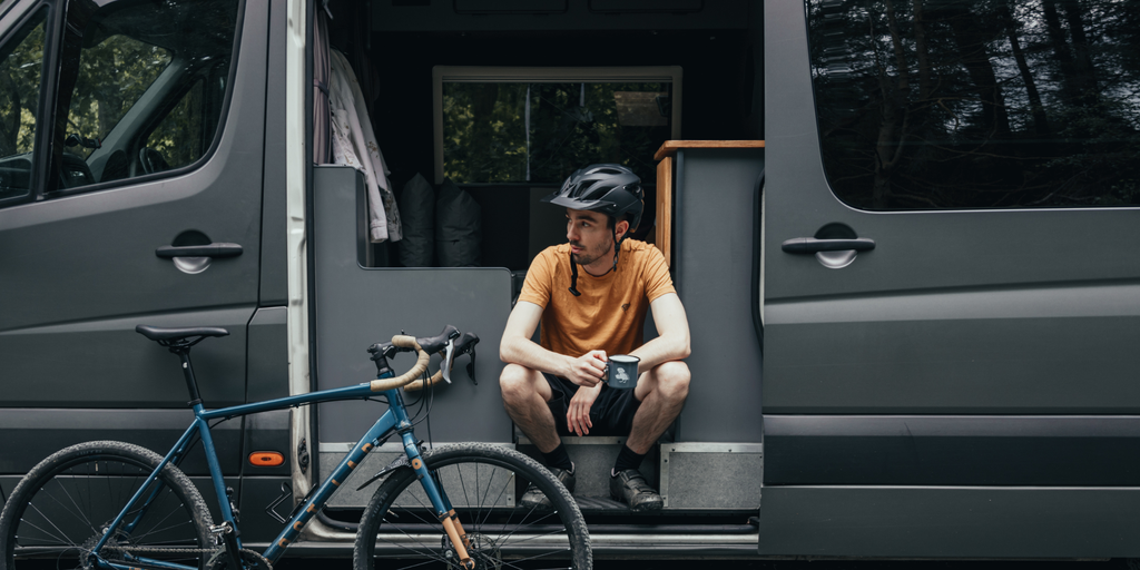 VW Crafter campervan 'Big Bert' overlooks Glencoe valley. Bicycles visible, hinting at Highlands adventure.
