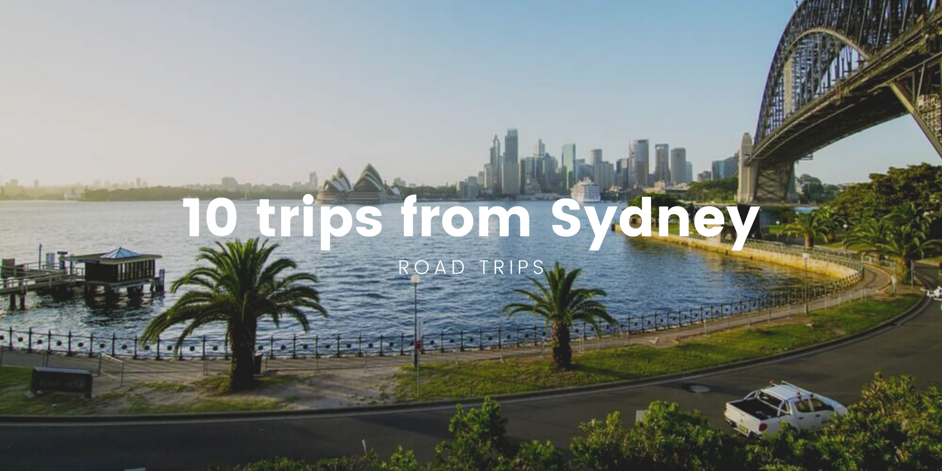 Campervan overlooking turquoise coastline on a sunny road trip from Sydney.