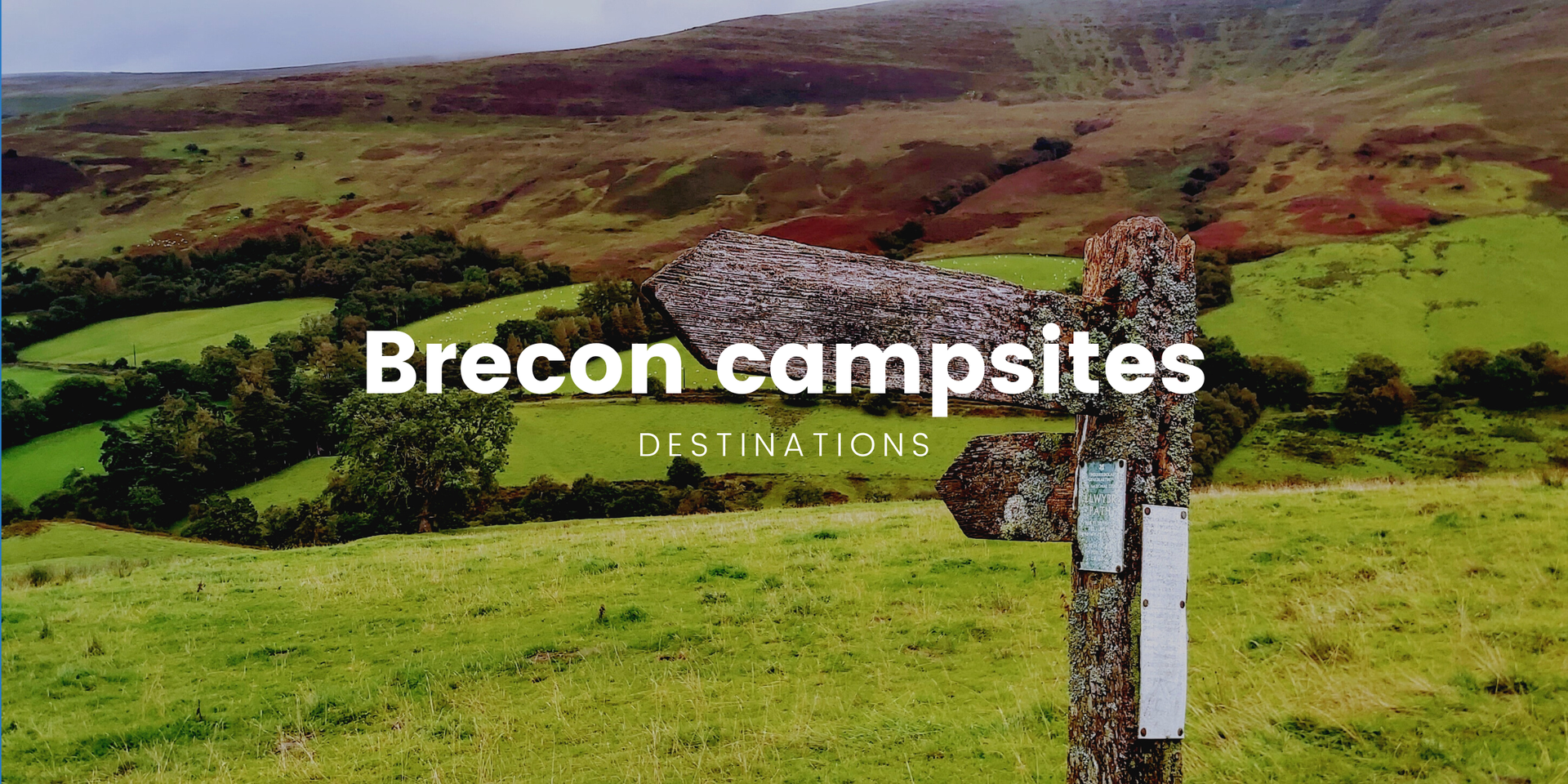 Tents pitched at scenic Brecon Beacons campsite. Rolling hills and mountains in background.