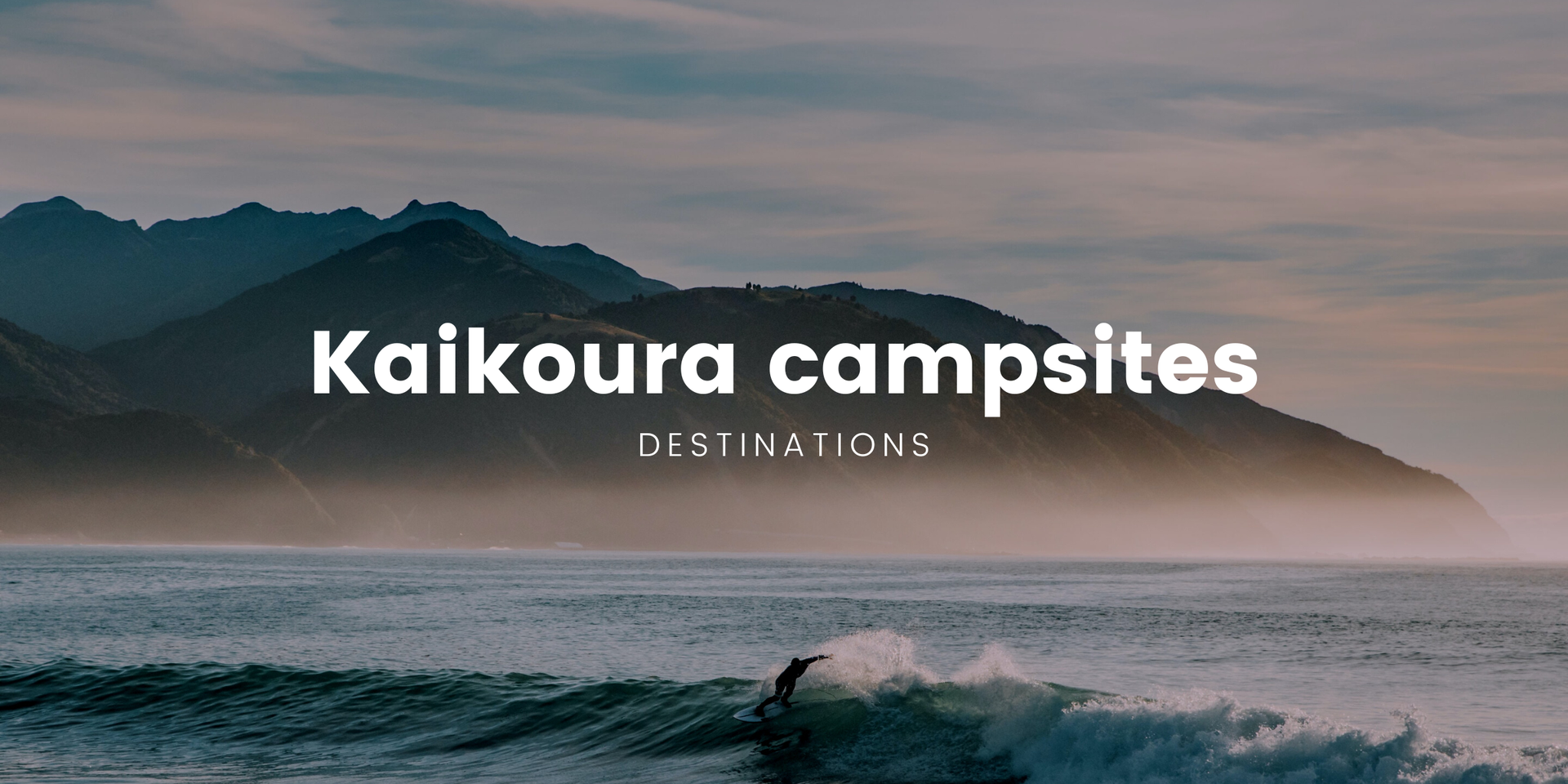 Kaikoura coastline campsite, tents pitched with campervan parked nearby, epic mountain backdrop.