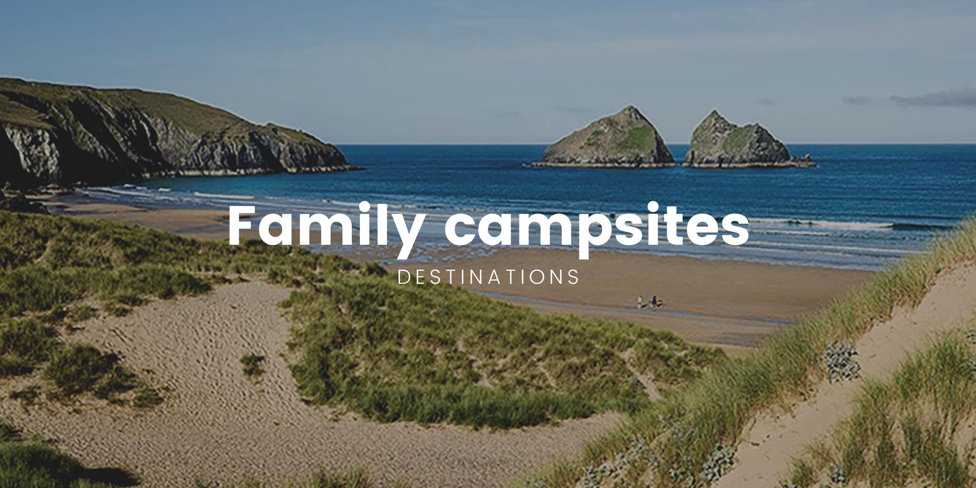 Family tent pitched at scenic campsite in the British countryside. Kids playing near a caravan.