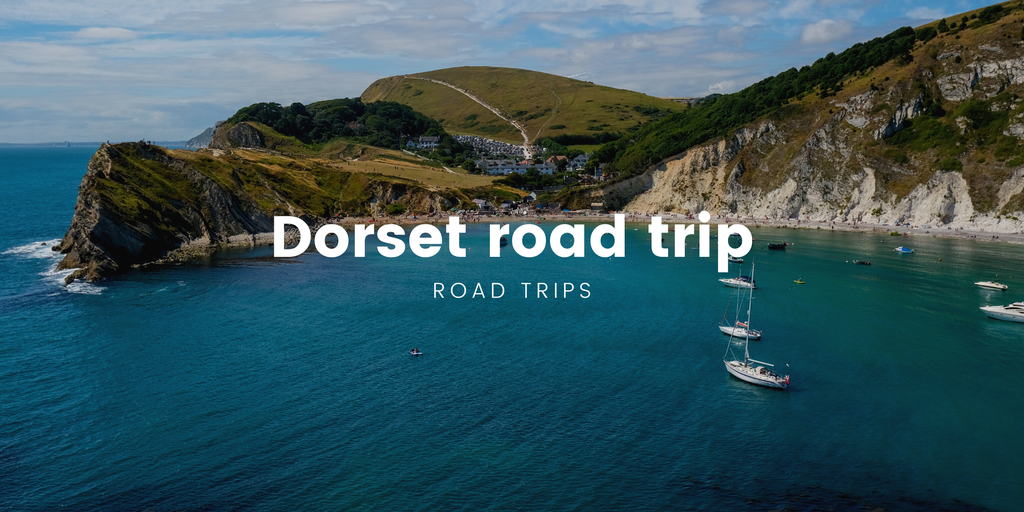 Campervan driving along winding road beside Dorset's Jurassic Coast. Holiday road trip.