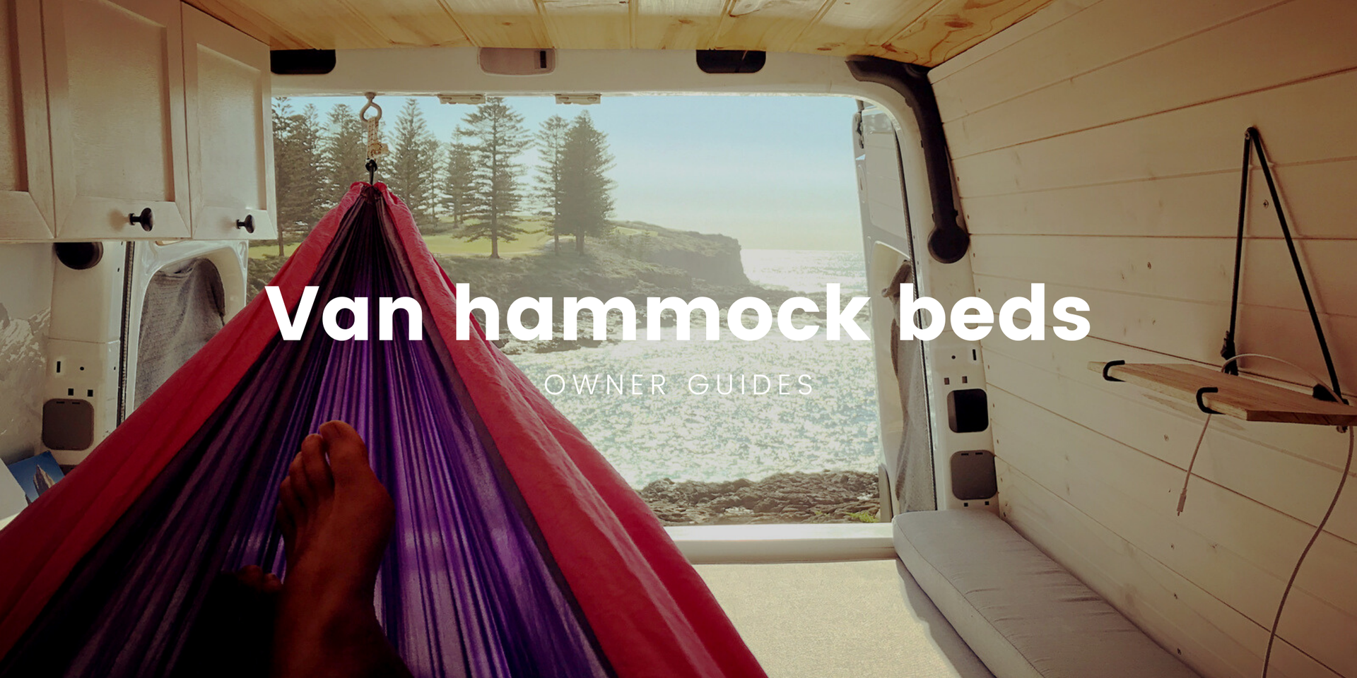 Campervan with hammock strung up inside, parked at a scenic campsite.