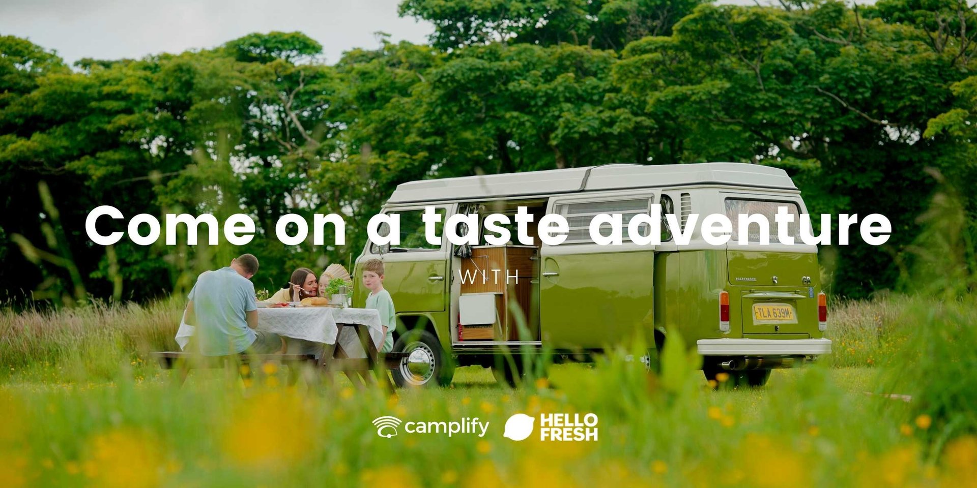Campervan parked up in scenic countryside, HelloFresh box on picnic table.