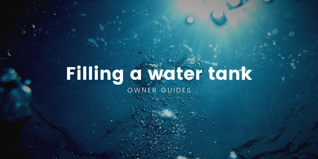 Motorhome at campsite water point, hose connected. Filling the water tank for a road trip.