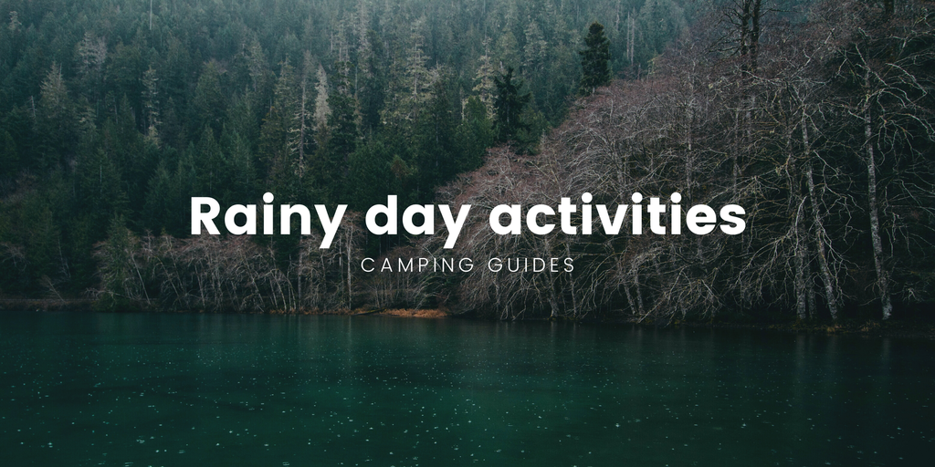 Family playing cards in tent on a rainy camping trip in the bush.