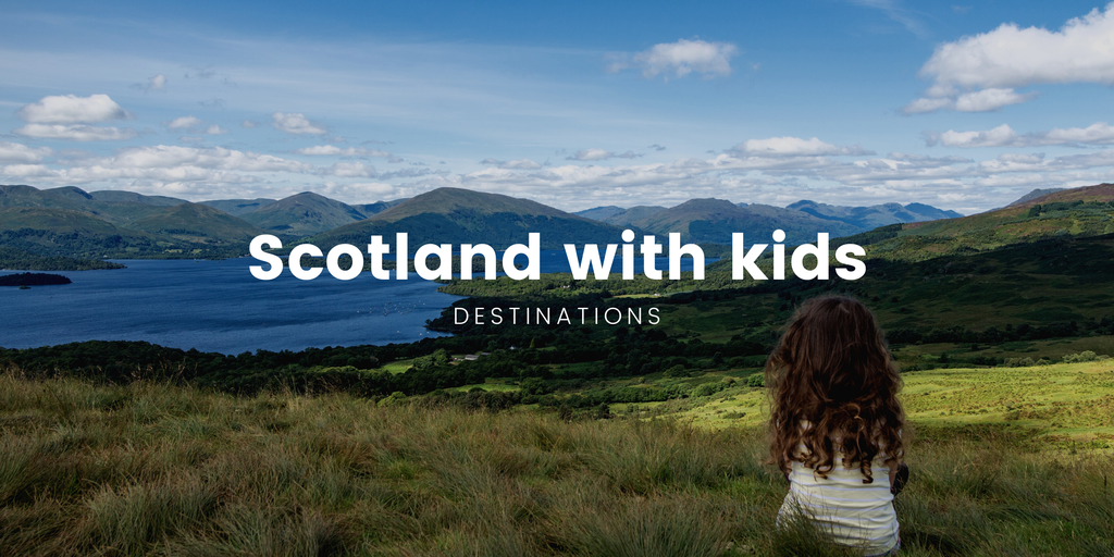 Family camping trip in the Scottish Highlands. Tent pitched by a loch, with mountains in the distance.