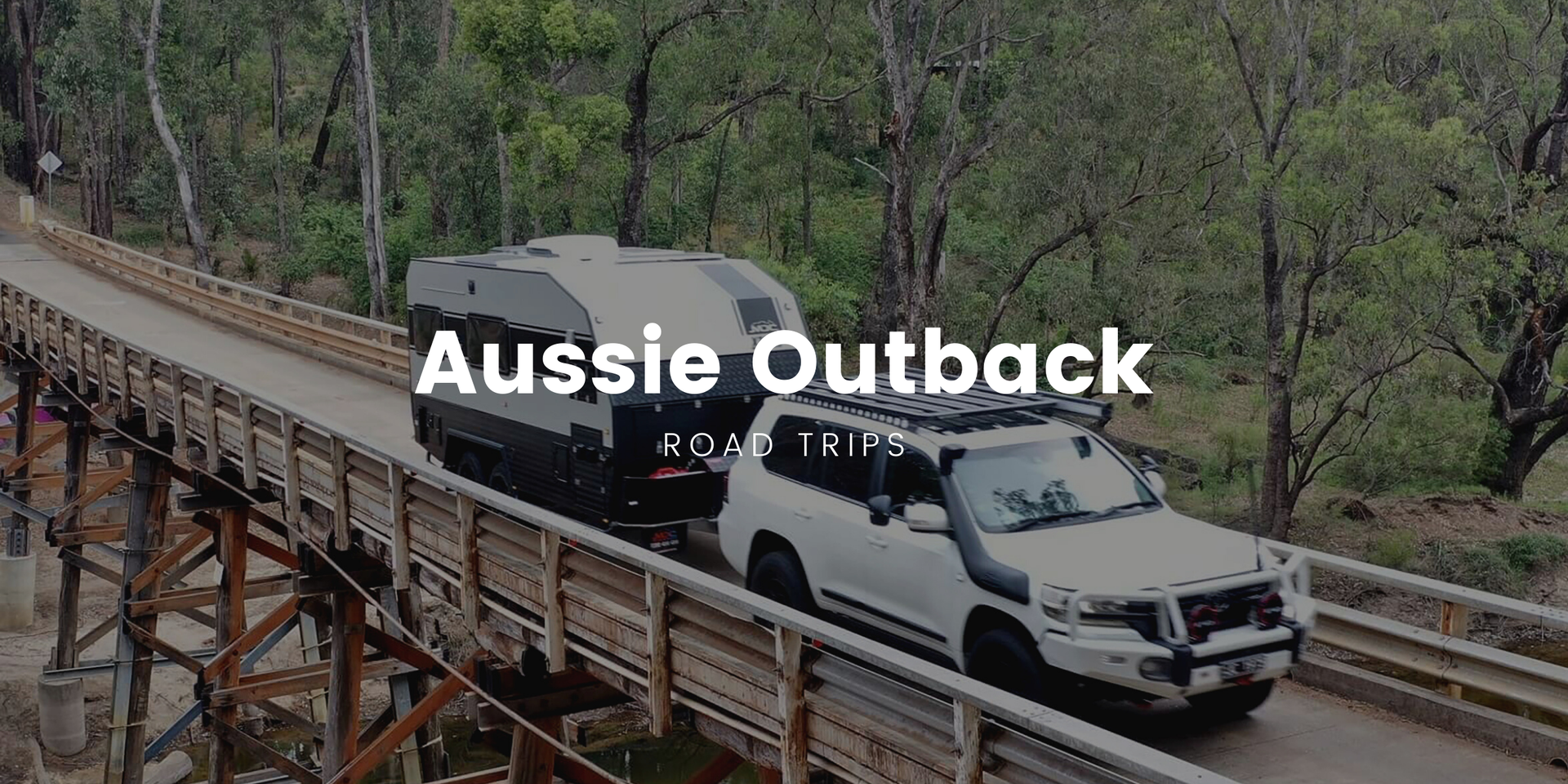 A 4WD loaded for camping cruises along a red dirt track in the Aussie outback.