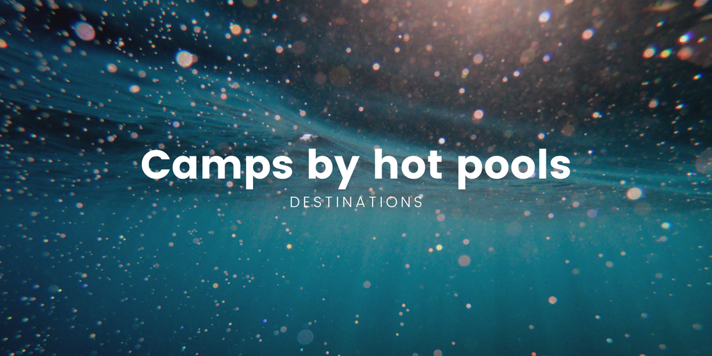 Camper parked at a campsite with steamy hot pools in the background, perfect for a relaxing Kiwi holiday.