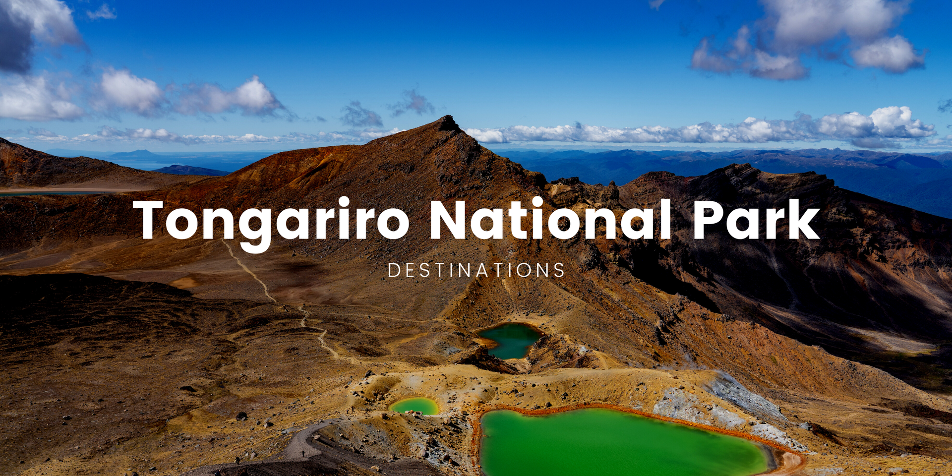 Snow-capped Mt Ngauruhoe towers over a campervan parked at a Tongariro National Park campsite.