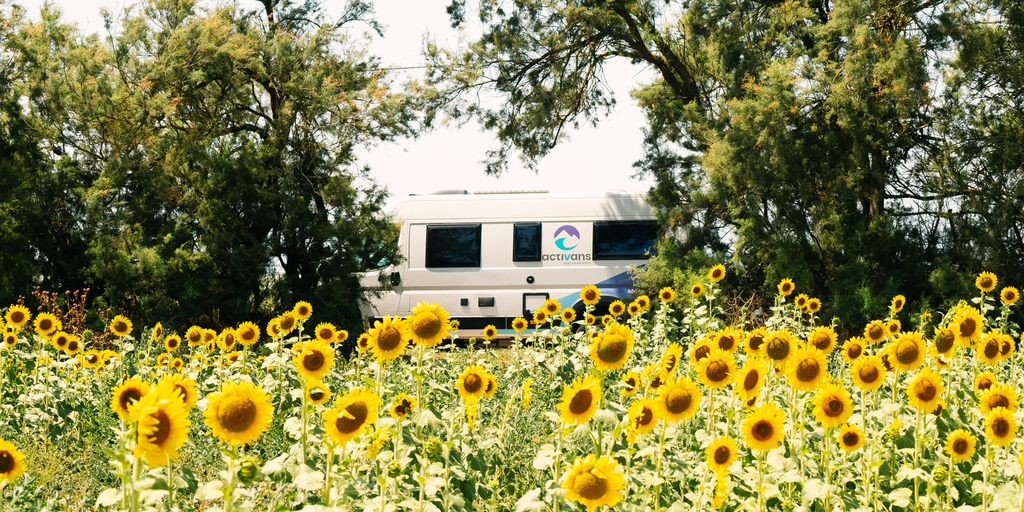 Autocaravana frente a playa española al atardecer. Vacaciones y aventura por la costa.