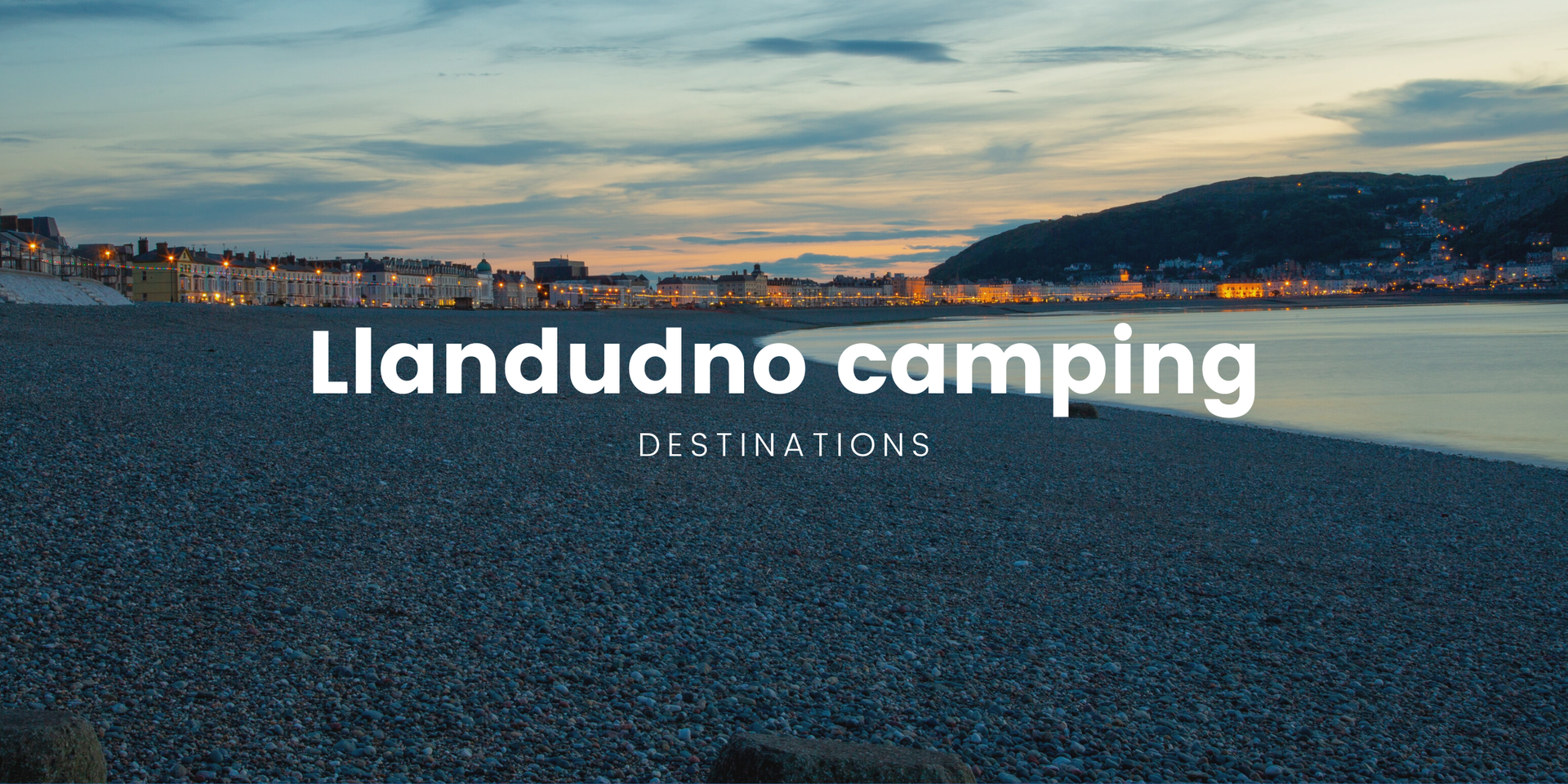 Tents and caravans at a Llandudno campsite with scenic views of the North Wales coast.