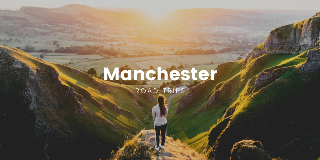 Campervan on a scenic road trip near Manchester, surrounded by rolling hills.