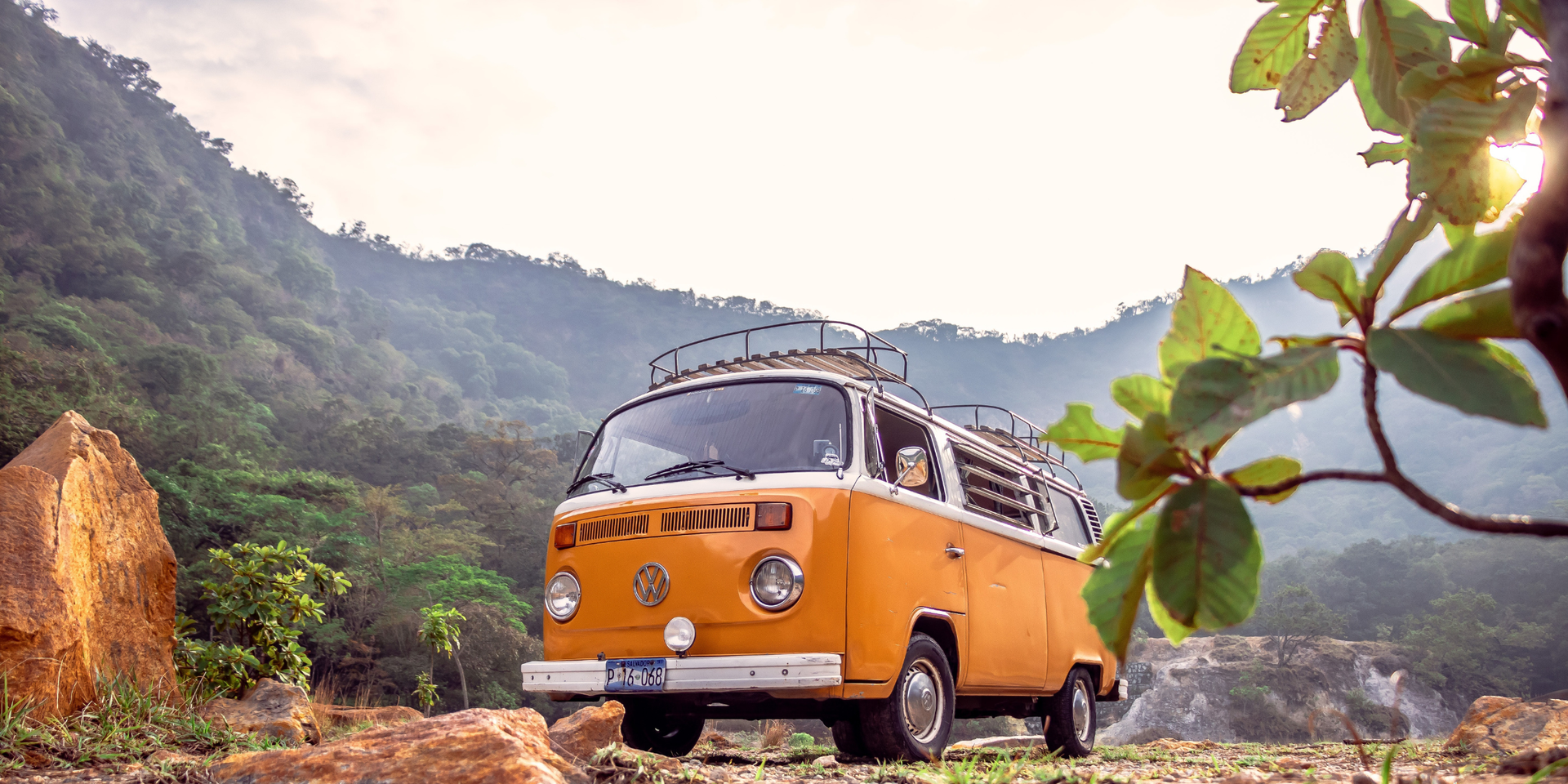 Caravan parked in a secure storage facility, surrounded by green fields on a sunny day.