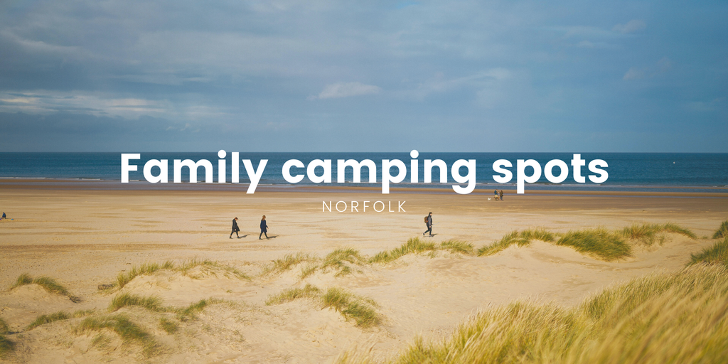 Family camping in Norfolk: Tent pitched on a sunny campsite with children playing.