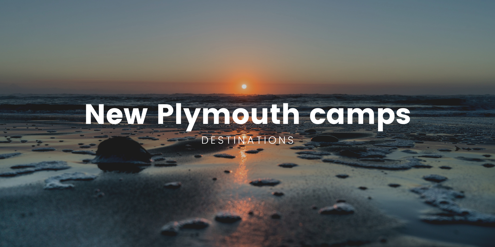 Tents pitched at a lush, green campground in Taranaki, with Mount Taranaki in the background.