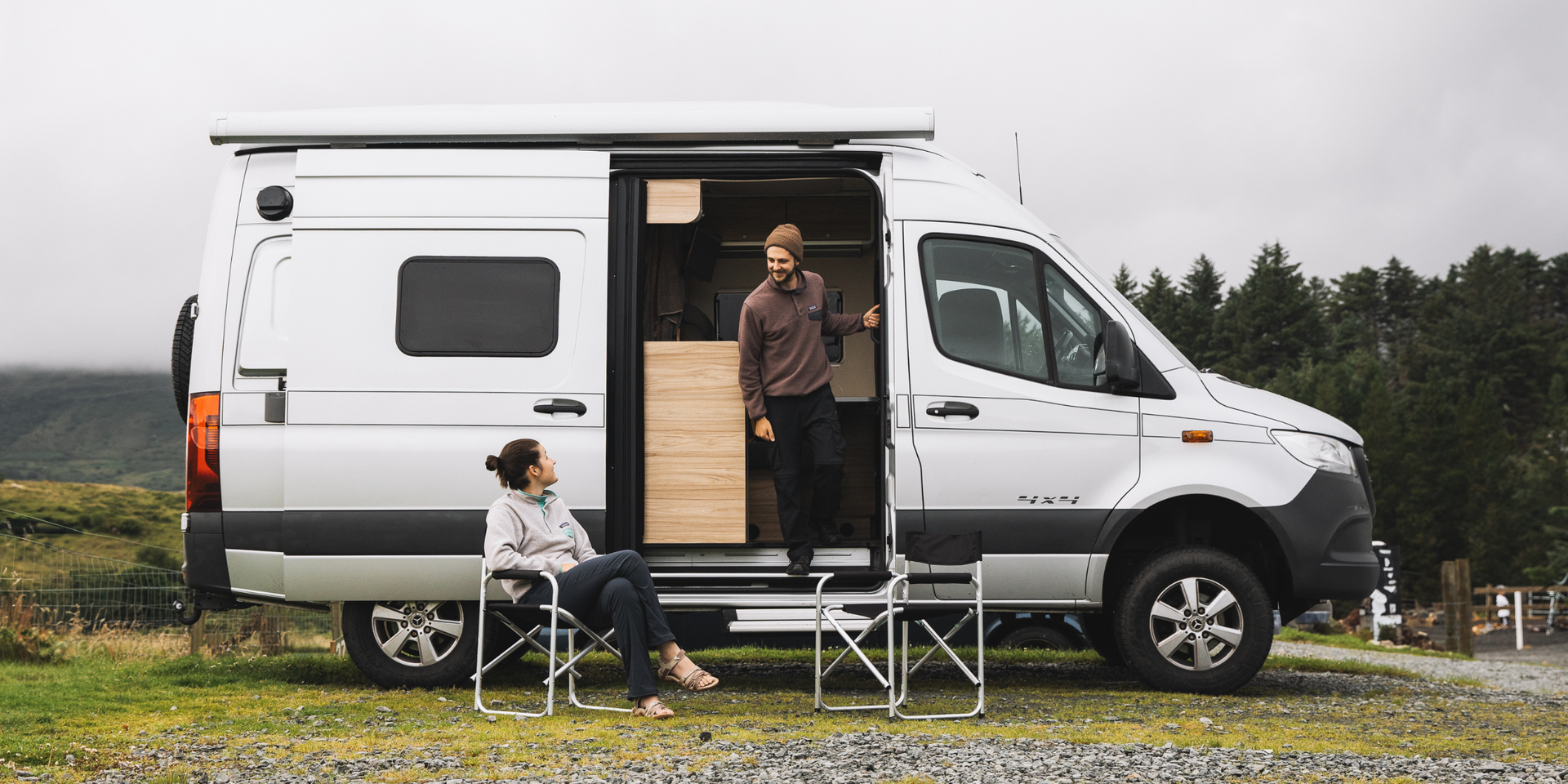 Campervan parked on clifftop overlooking scenic British coastline. Holiday adventure.