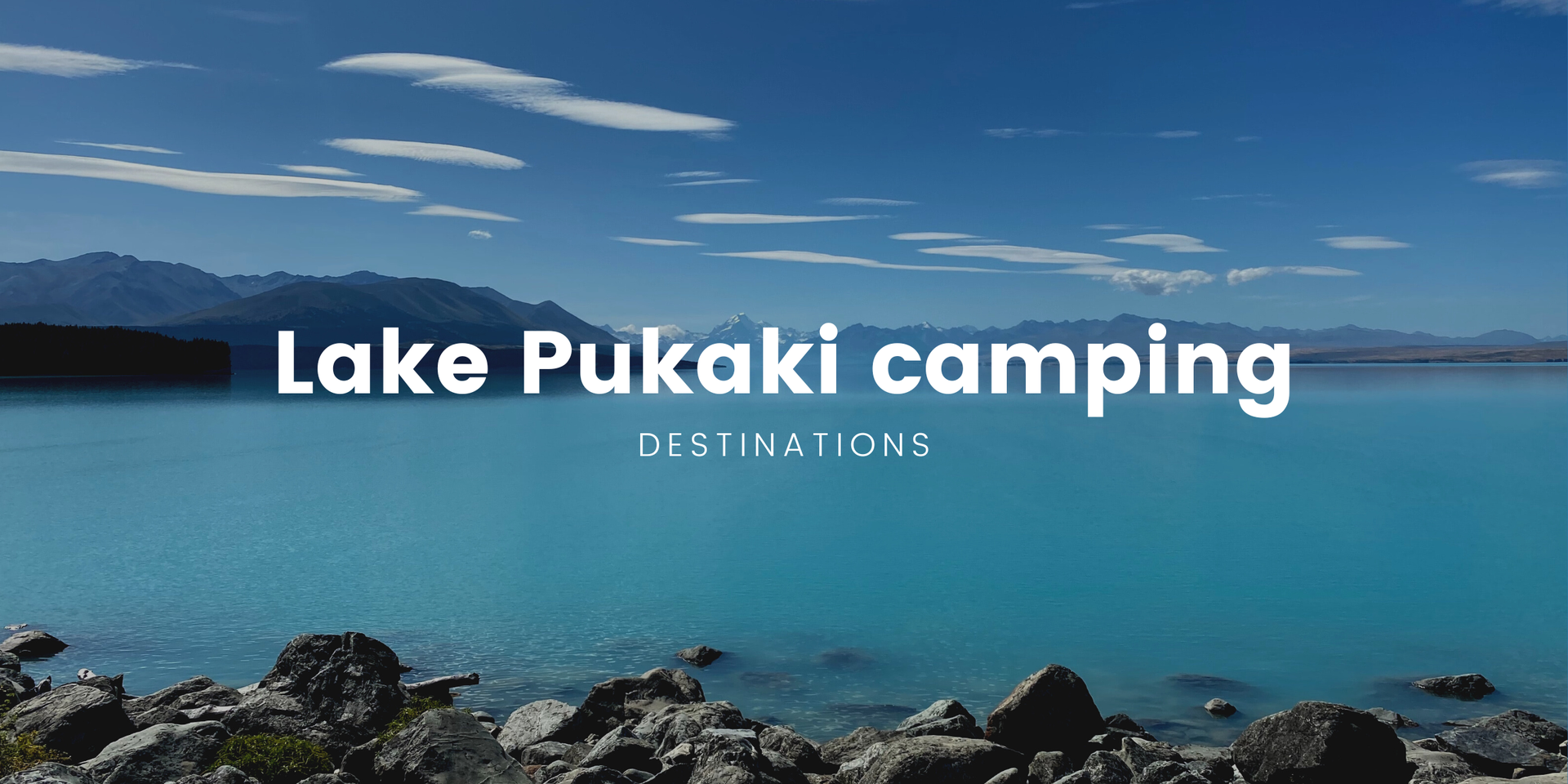 Lake Pukaki campsite with snow-capped mountains reflected in turquoise water.