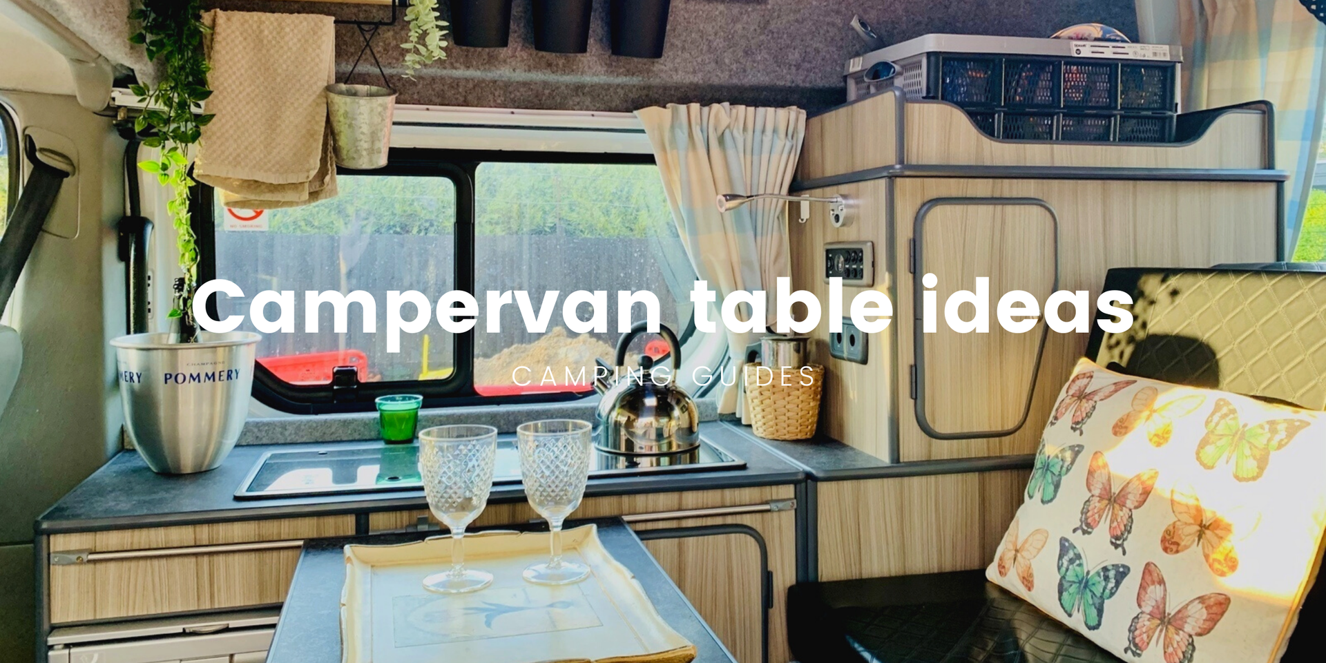 Campervan parked up in scenic countryside; outdoor table set for a meal.